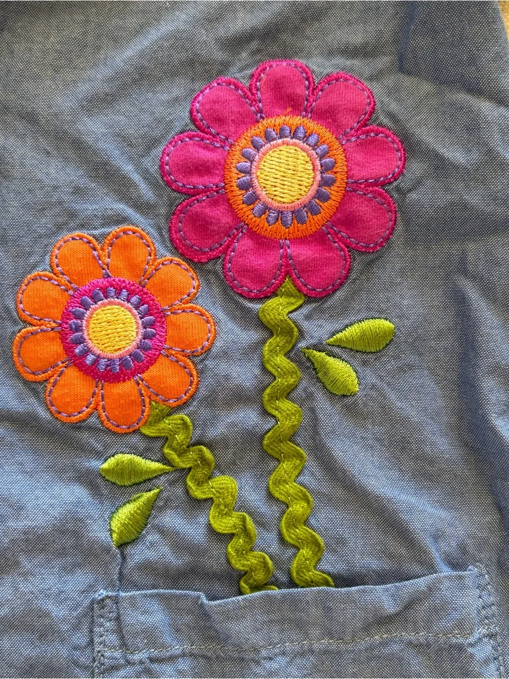 Girls Blue chambray dress with flower appliqué, flared sleeves, and floral lace